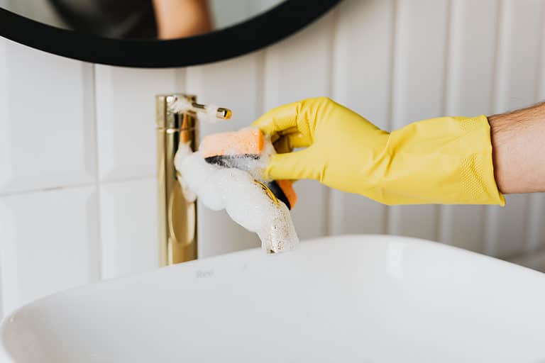 cleaning a tap with soap, cleaning chemical and scrubbing pad